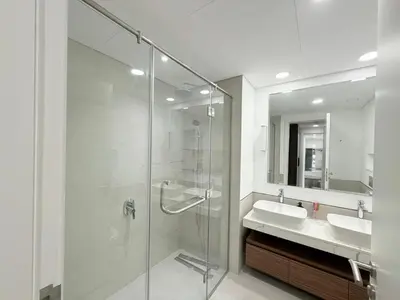 a bathroom with a glass shower and a sink at Stunning 3BR Retreat with Panoramic Sunset Views in Dubai