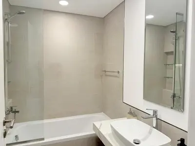a bathroom with a tub and a sink and a mirror at Stunning 3BR Retreat with Panoramic Sunset Views in Dubai