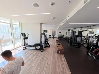 a man in a gym with several tread machines at Orange Plumeria 1701 - 2BR SeaView with Prvt Beach in Dubai