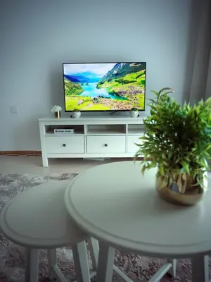 a living room with a tv on a white entertainment center at Sunsand Studio at Dubai Marina in Dubai