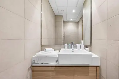 a bathroom with a white sink and a mirror at Chic Modern Studio in Meydan Azizi Riviera 26 in Dubai