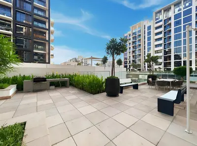 a patio with benches and tables and buildings at Chic Modern Studio in Meydan Azizi Riviera 26 in Dubai