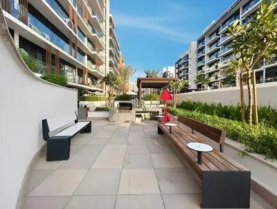 a walkway with benches and tables in a building at Chic Modern Studio in Meydan Azizi Riviera 26 in Dubai
