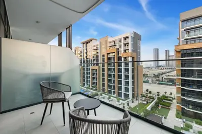 a balcony with two chairs and a view of a city at Chic Modern Studio in Meydan Azizi Riviera 26 in Dubai