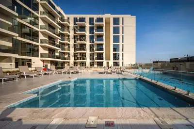 a large swimming pool in front of a building at 10 min to Dubai Marina - New Cozy 1 Bed in JVT in Dubai
