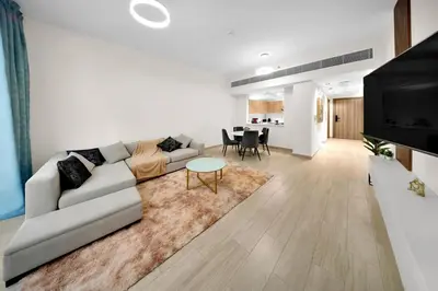 a living room with a couch and a table at 10 min to Dubai Marina - New Cozy 1 Bed in JVT in Dubai
