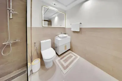 a bathroom with a toilet and a sink and a mirror at 10 min to Dubai Marina - New Cozy 1 Bed in JVT in Dubai
