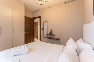 a bedroom with a large white bed with white pillows at HAVN - 1 bedroom in Sobha Creek, MBR City in Dubai