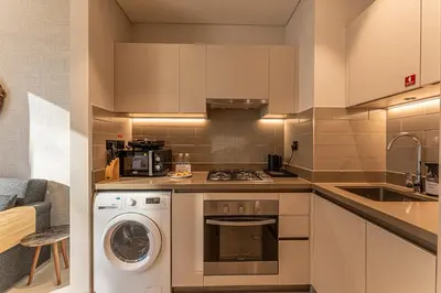 a kitchen with a washer and dryer in it at HAVN - 1 bedroom in Sobha Creek, MBR City in Dubai