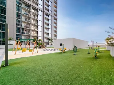 a playground in front of a tall building at HAVN - 1 bedroom in Sobha Creek, MBR City in Dubai