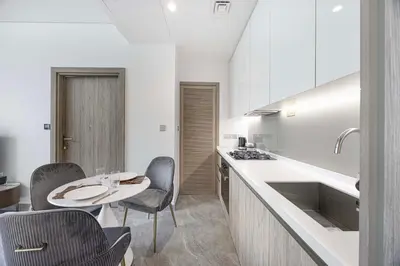 a kitchen with a table and chairs and a sink at LUX 1 BDR apartment Downtown - Burj Khalifa view in Dubai