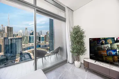 a living room with a large window with a view of the city at LUX 1 BDR apartment Downtown - Burj Khalifa view in Dubai
