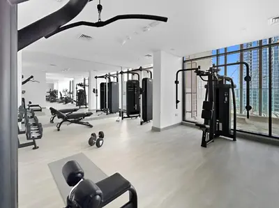 a gym with several treadmills and machines at Bright Modern Studio in Meydan Azizi Riviera 40 in Dubai