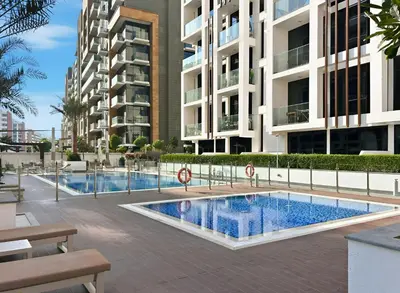 a swimming pool in front of a building at Bright Modern Studio in Meydan Azizi Riviera 40 in Dubai