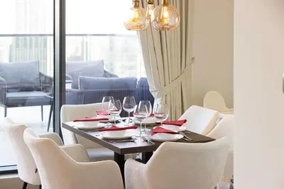 a dining room table with wine glasses and chairs at Luxury Downtown 2 Bedroom Apartment with amazing Burj and Fountain Views and Private Jacuzzi on a large Terrace in Dubai