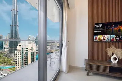 a room with a large window with a view of a city at Luxury Downtown 2 Bedroom Apartment with amazing Burj and Fountain Views and Private Jacuzzi on a large Terrace in Dubai