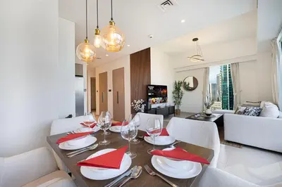 a dining room and living room with a table and chairs at Luxury Downtown 2 Bedroom Apartment with amazing Burj and Fountain Views and Private Jacuzzi on a large Terrace in Dubai