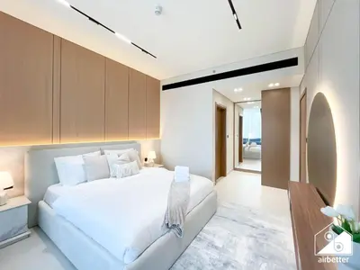 a bedroom with a white bed and a couch at 2BR Panoramic Skyline Haven with Jacuzzi in Dubai