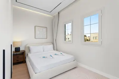 a white bedroom with a bed and a window at Cozy 2Bedroom Villa with Private Pool in Springs in Dubai
