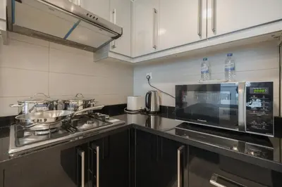 a kitchen with a stove and a microwave at Spacious apt City view Gym and pool in Dubai