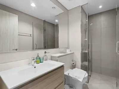 a white bathroom with a sink and a shower at Zada Glam Sleek 1BDR Retreat-Business Bay-25 in Dubai