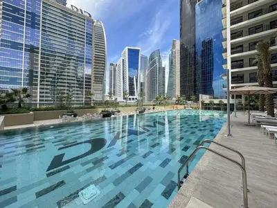 a large swimming pool in a city with tall buildings at Zada Glam Sleek 1BDR Retreat-Business Bay-25 in Dubai