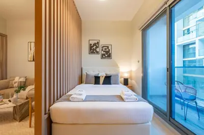 a bedroom with a bed and a large window at Exquisite Studio by UDH Sway Residence at Dubai Hills in Dubai