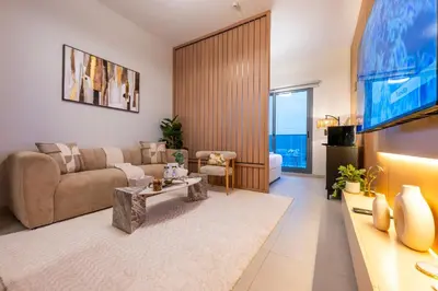 a living room with a couch and a tv at Exquisite Studio by UDH Sway Residence at Dubai Hills in Dubai