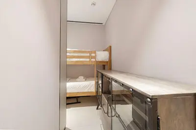 a small room with a desk and bunk beds at Address Beach Resort 3 Bedroom with Sea and Palm Views in Dubai