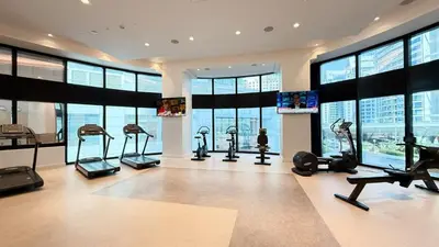 a gym with cardio equipment in a building with windows at Address Beach Resort 3 Bedroom with Sea and Palm Views in Dubai