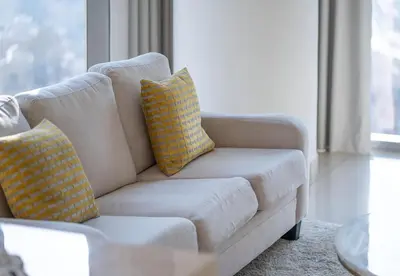 a white couch with yellow pillows in a living room at Luxury 2 Bed in Boulevard Point with City Views in Dubai