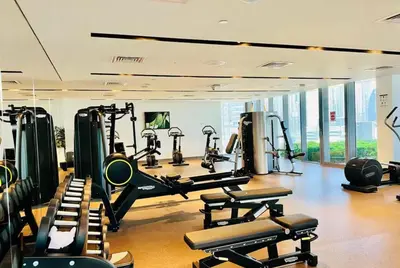a gym with rows of tread machines in a room at Luxury 2 Bed in Boulevard Point with City Views in Dubai