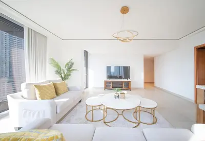 a living room with a white couch and a table at Luxury 2 Bed in Boulevard Point with City Views in Dubai