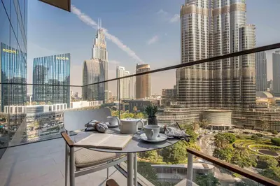 a table on a balcony with a view of a city at Frank Porter - Address Residences Dubai Opera Tower 1 in Dubai