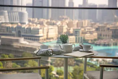 a table with cups and saucers with a view of a city at Frank Porter - Address Residences Dubai Opera Tower 1 in Dubai