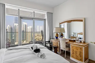 a bedroom with a bed and a desk and a mirror at Elegant 3 BR plus Maids Infinity Pool Burj View in Dubai