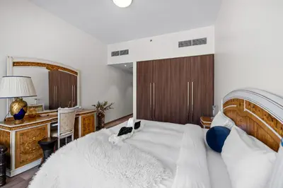 a bedroom with a bed and a desk and a mirror at Elegant 3 BR plus Maids Infinity Pool Burj View in Dubai
