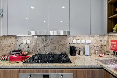 a kitchen with a stove and a counter top at Elegant 3 BR plus Maids Infinity Pool Burj View in Dubai