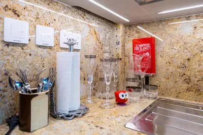 a kitchen counter with wine glasses and a sink at Elegant 3 BR plus Maids Infinity Pool Burj View in Dubai