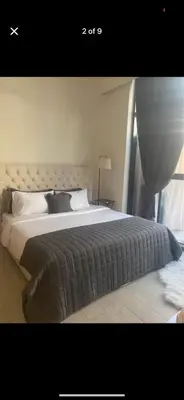 a bedroom with a large bed with a large window at Holiday homes azizi riviera in Dubai