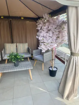 a room with two chairs and a tree with flowers at Holiday homes azizi riviera in Dubai