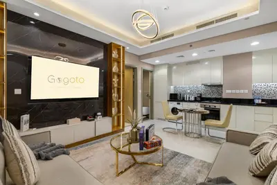 a living room with a tv and a kitchen at Gogoto5 1BR Burj View Infinity Pool High Floor in Dubai