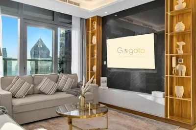 a living room with a couch and a tv at Gogoto5 1BR Burj View Infinity Pool High Floor in Dubai