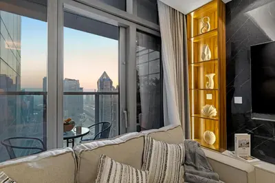 a living room with a couch and a large window at Gogoto5 1BR Burj View Infinity Pool High Floor in Dubai