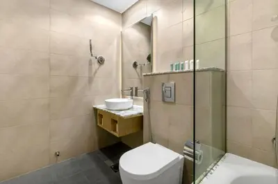 a bathroom with a toilet and a sink and a shower at Gogoto5 1BR Burj View Infinity Pool High Floor in Dubai