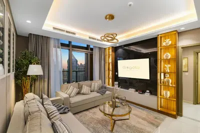 a living room with a couch and a tv at Gogoto5 1BR Burj View Infinity Pool High Floor in Dubai