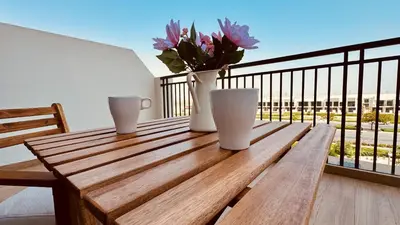 a wooden table with a vase of flowers on a balcony at Premium Guest - Liva Serenity Suite in Dubai