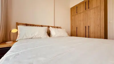 a bedroom with a large white bed with a wooden cabinet at Premium Guest - Liva Serenity Suite in Dubai