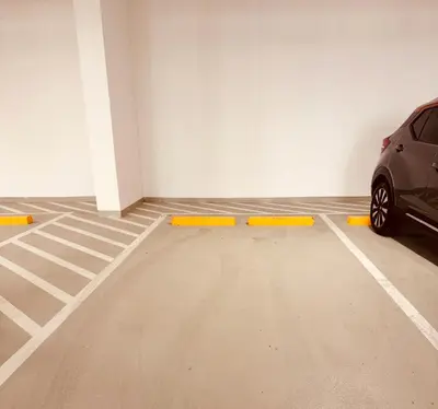 a car parked in a parking garage with yellow poles at Premium Guest - Liva Serenity Suite in Dubai