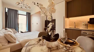 a living room with a table with a vase with flowers at Premium Guest - Dubai Riviera in Dubai